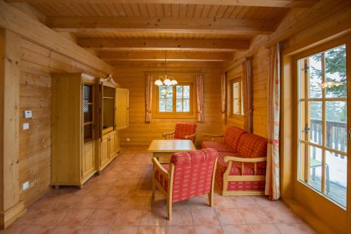 a room with a table and chairs in a cabin at Feriendorf Koralpe Chalet Gamssprung in St. Gertraud