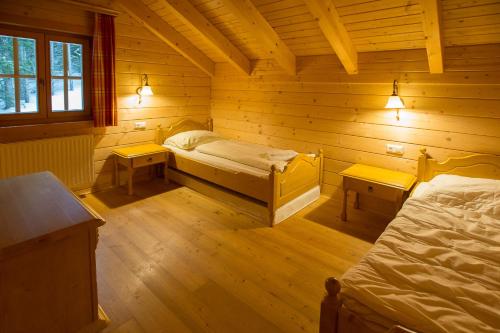 a room with two beds in a log cabin at Feriendorf Koralpe Chalet Gamssprung in St. Gertraud