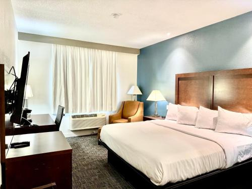 a hotel room with a large bed and a desk at Baymont by Wyndham Richmond I-70 in Richmond
