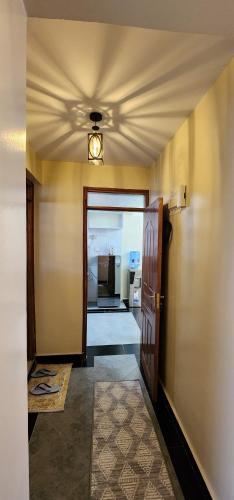 a hallway with a ceiling fan and a door at The Hidden Hearth 2Bedroom in Nakuru