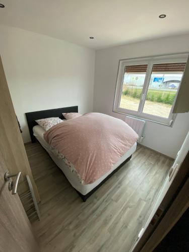 une chambre avec un lit et une fenêtre dans l'établissement Petite maison chaleureuse, à Appoigny