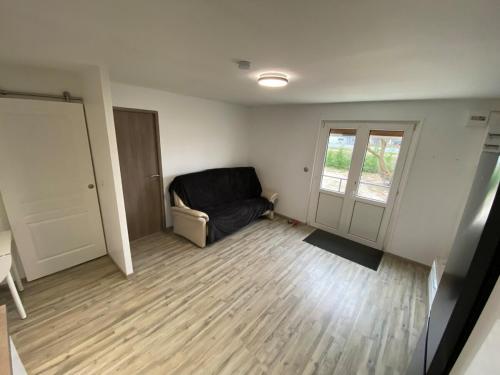 un salon avec un canapé et une fenêtre dans l'établissement Petite maison chaleureuse, à Appoigny