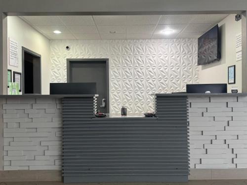 a lobby with a reception desk in a building at Ramada by Wyndham Tuscaloosa in Tuscaloosa
