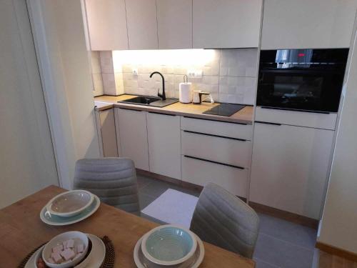 a small kitchen with a wooden table and chairs at Relax sauna apartman in Divčibare