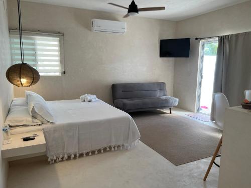 a bedroom with a bed and a blue chair at Villa Cayetano in Mahahual