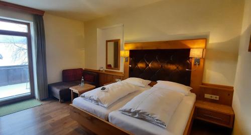 a bedroom with a large bed and a window at Hotel Gasthof Jägerhaus in Sankt Peter