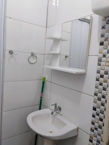 a white bathroom with a sink and a mirror at Studio próximo às Cataratas do Iguaçu in Foz do Iguaçu