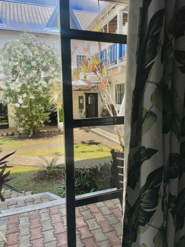 a window with a view of a building at Bananaquit Tobago -Stay Near the Beach in Crown Point