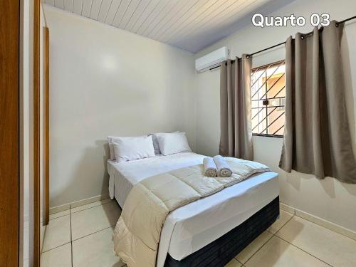 a bed in a room with a window at Casa 3quartos sinuca prox Paraguai e Itaipu in Foz do Iguaçu
