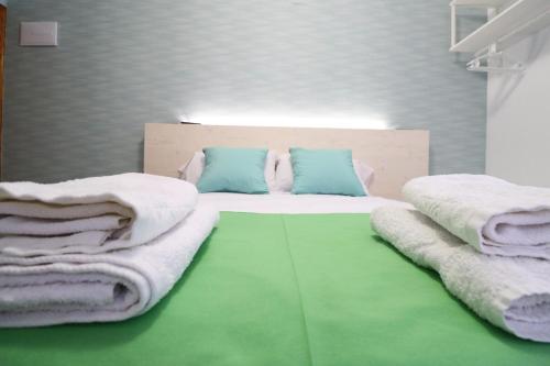a bedroom with a bed with towels on it at Hotel Posada del Mar Playa de Gandía in Puerto de Gandía