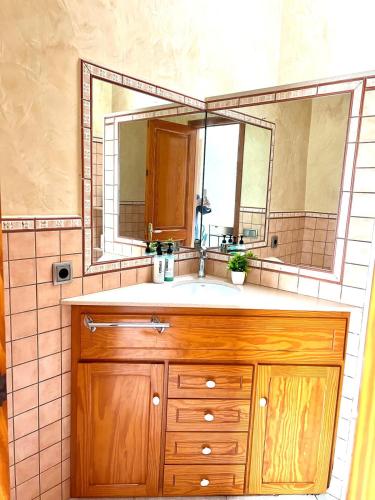 a bathroom with a wooden sink and a mirror at Villa Tonia in Cala en Blanes