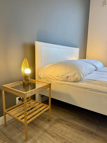 a bedroom with a bed and a table with a lamp at JTB Nautica Aparthotel in Szczecin