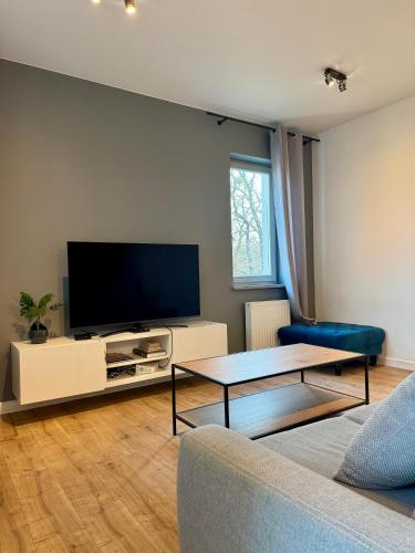 a living room with a couch and a tv at JTB Nautica Aparthotel in Szczecin