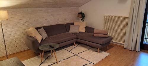 ヒッティザウにあるFerienwohnung Meusburgerのリビングルーム(ブラウンソファ、テーブル付)