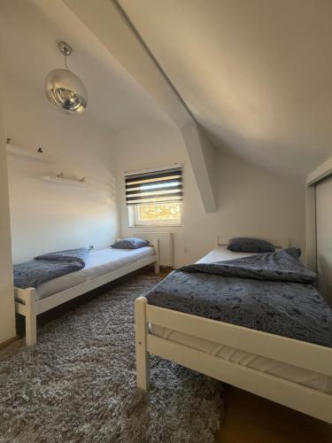 a bedroom with two beds and a window at Luxury Studio Black & White in Sarajevo