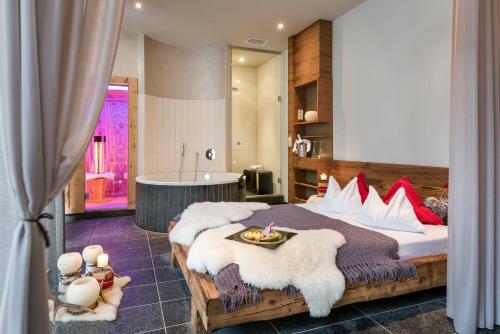 a bedroom with a large bed and a bath tub at Hotel Das Rübezahl in Schwangau