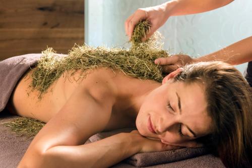 a woman laying on the floor with grass on her back at Hotel Das Rübezahl in Schwangau