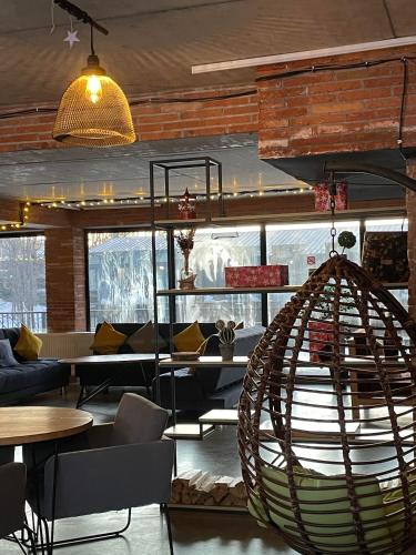 a room with tables and chairs and a hanging chair at Mgzavrebi 10 in Bakuriani
