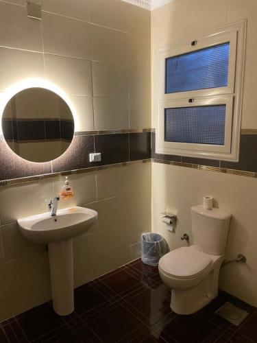 a bathroom with a toilet and a sink and a mirror at Diyar Pyramids Inn in Cairo