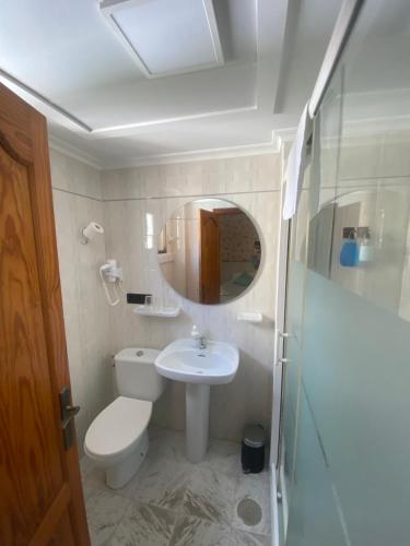 a bathroom with a toilet and a sink and a mirror at Hotel Posada del Mar Playa de Gandía in Puerto de Gandía