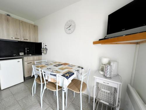 une cuisine avec une table avec des chaises et un réfrigérateur dans l'établissement Cozy nest sea view, à Les Sables-dʼOlonne