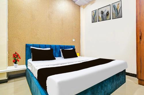 a bedroom with a bed with blue and white at Hotel O Hanuman Naka Ujjain Formerly Krishna Palace in Ujjain