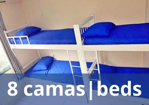 two bunk beds with blue pillows and the words canas beds at Solar Hostel Beach Copacabana in Rio de Janeiro