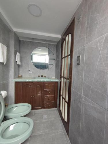 a bathroom with two toilets and a sink and a mirror at La culta elegante in Sucre