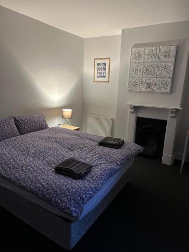 a bedroom with a bed and a fireplace at Luton Town House Near AIRPORT in Luton