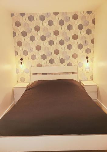 - une chambre dotée d'un lit avec un mur hexagonal dans l'établissement Le Cocon Palmier, à Vitré