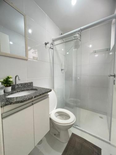 a bathroom with a toilet and a glass shower at Apartamento Duplex in Uberaba
