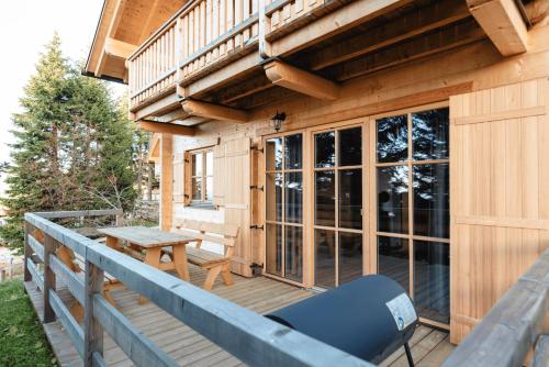 a porch of a cabin with a table and chairs at Feriendorf Koralpe Chalet Speik XL 27 in St. Gertraud