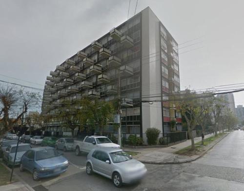 a parking lot with cars parked in front of a building at Céntrico Depto - Viña del Mar in Viña del Mar