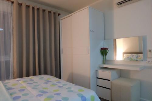 ein Schlafzimmer mit einem Bett, einer Kommode und einem Spiegel in der Unterkunft nap nap like home 2 in Sathani Khlong Rian