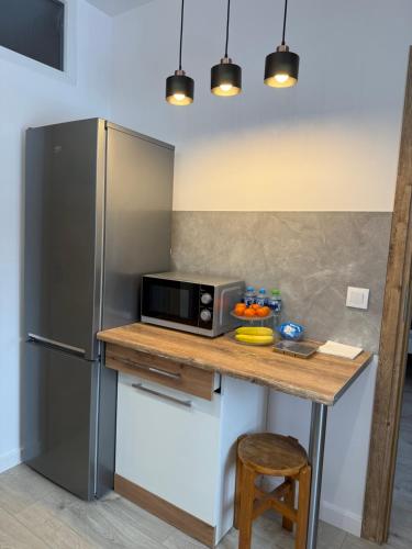 a kitchen with a counter with a microwave and a refrigerator at APARTAMENT NATALIA in Marciszów