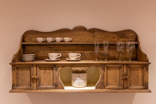 a wooden shelf with cups and plates and wine glasses at Palazzo Doni by Florence Art Apartments in Florence