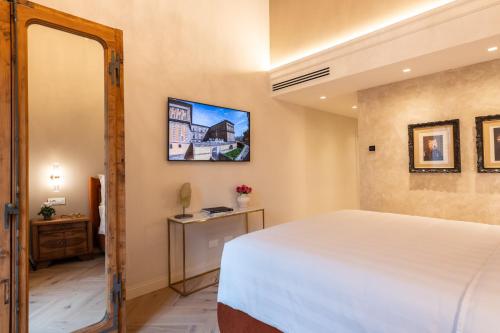 a bedroom with a white bed and a mirror at Palazzo Doni by Florence Art Apartments in Florence