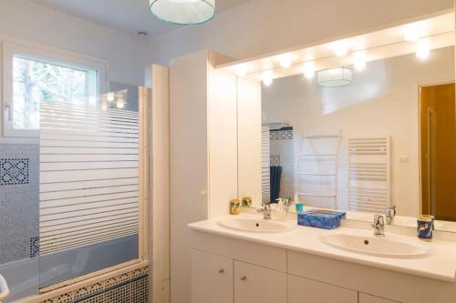 une salle de bain avec deux lavabos et un grand miroir dans l'établissement Maison esprit cabane proche océan et bassin, à Lège-Cap-Ferret