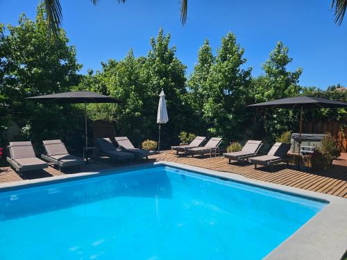 a swimming pool with lounge chairs and umbrellas at Casa Calfu in Santa Cruz