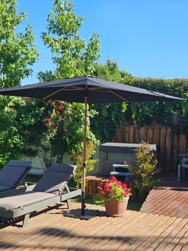 a black umbrella in a patio with chairs and a table at Casa Calfu in Santa Cruz