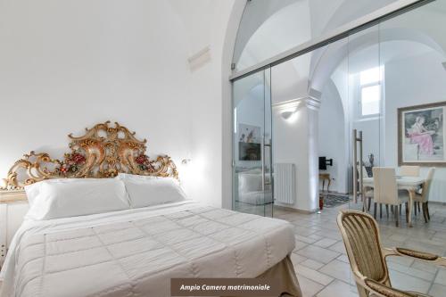 a bedroom with a large bed and a dining room at Antoglietta 19 Old Town - Lecce Selection in Lecce