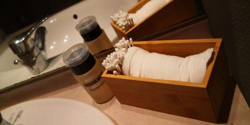 a wooden box filled with toilet paper next to a sink at Chez Soso in Luchon