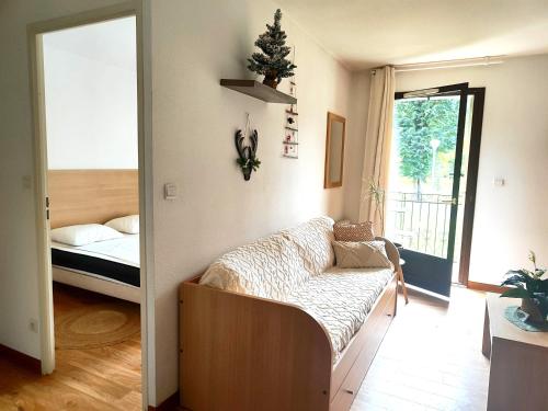 a room with a couch and a bed and a window at Chez Soso in Luchon