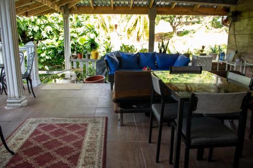 eine Terrasse mit einem blauen Sofa, einem Tisch und Stühlen in der Unterkunft PRI Studio Apartment in Arnos Vale