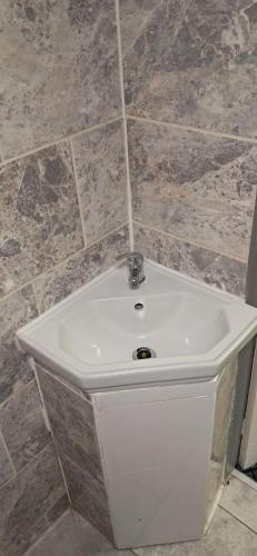 a white sink in a bathroom with tile walls at Park hotel in Bradford