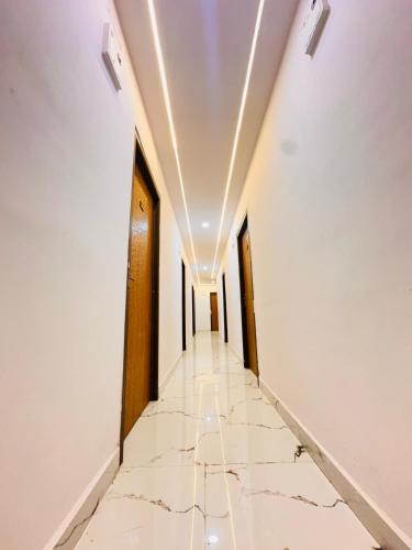 a corridor of a building with white walls and marble floors at K7 Hotel & Restaurant in Rānchī