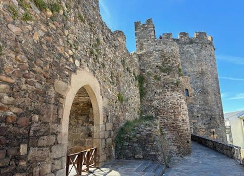 an old stone building with an archway in front of it at Hotel & Restaurante El Casino in Villafranca del Bierzo