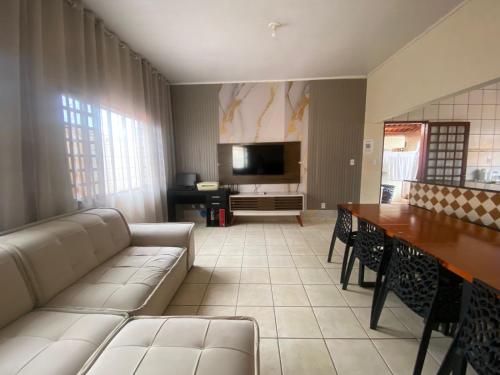 a living room with a couch and a table at Aconchego - Casa 3/4 - ar condicionado nos 3/4 -garagem in Palmas