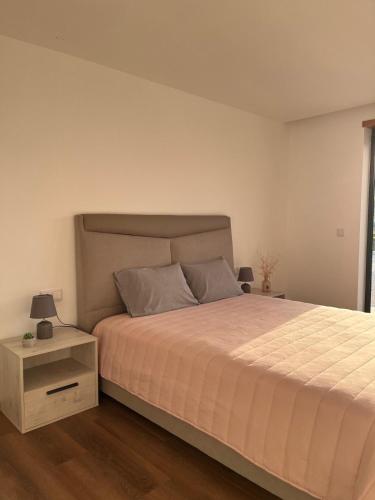 a bedroom with a large bed and a night stand at Sunny Haven-Villa in Ponte de Lima