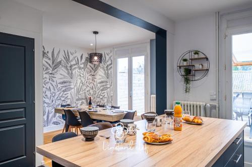 une salle à manger avec une table sur laquelle se trouve de la nourriture dans l'établissement Maison d exception au Mans Garage XXL et Terrasse, au Mans
